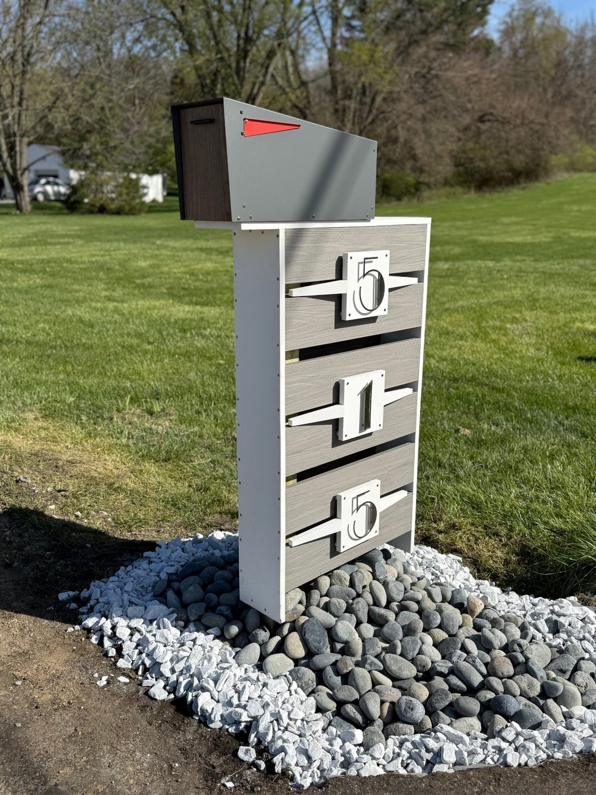 Finished custom mailbox — composite slatted post with address numerals, river-rock bed